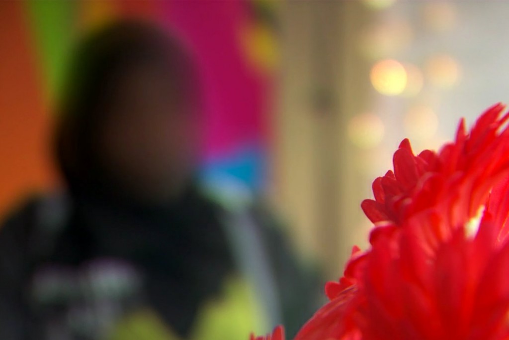 muslim girl blurred with red flower denoting FGM