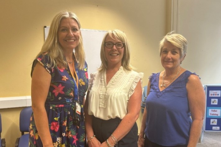 3 women standing and smiling into the camera