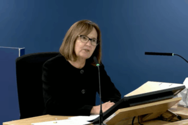 woman sat at podium