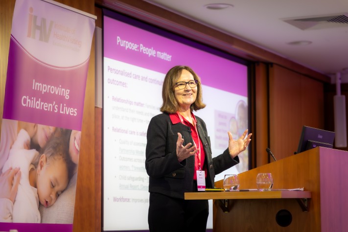 woman standing at lectern presenting