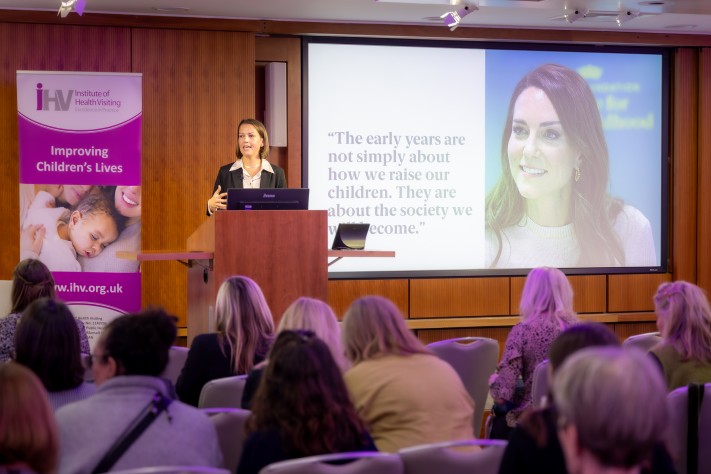 woman at lectern presenting to conference